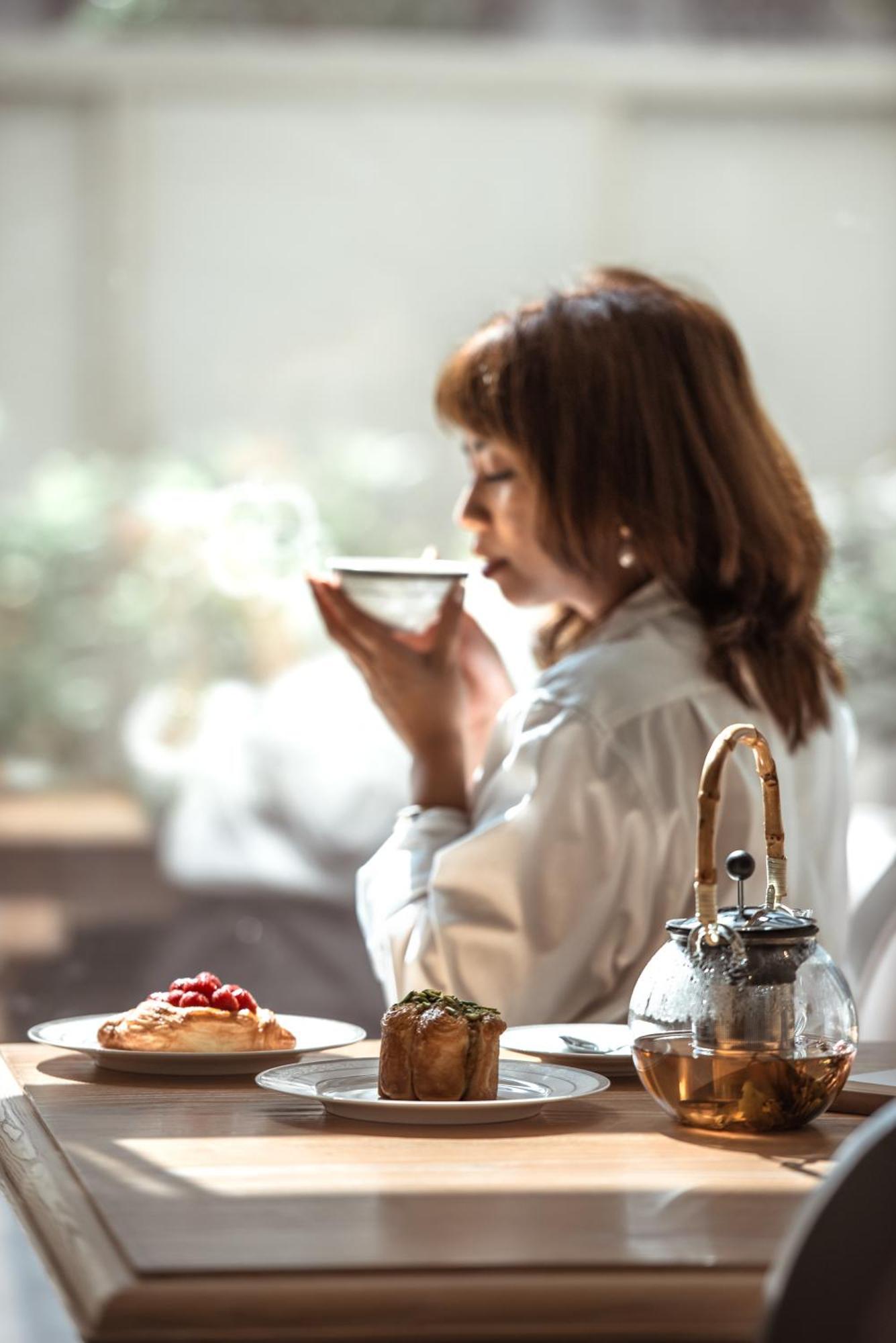 Dusit Doha Hotel Eksteriør billede A woman drinking tea